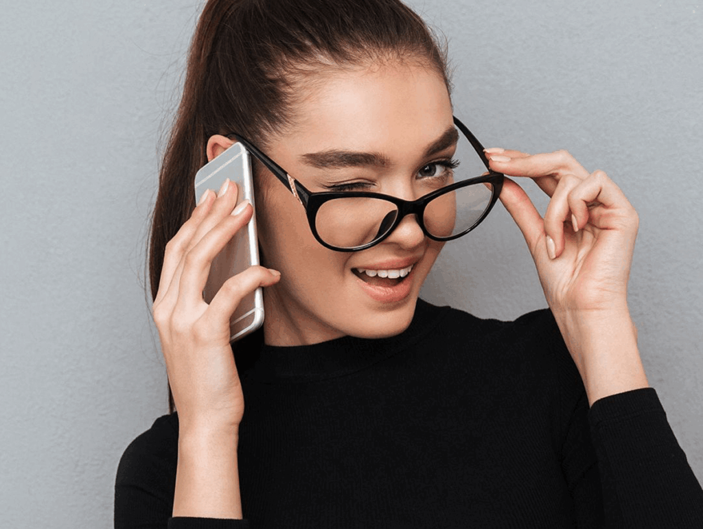 Mulher usando óculos e celular.