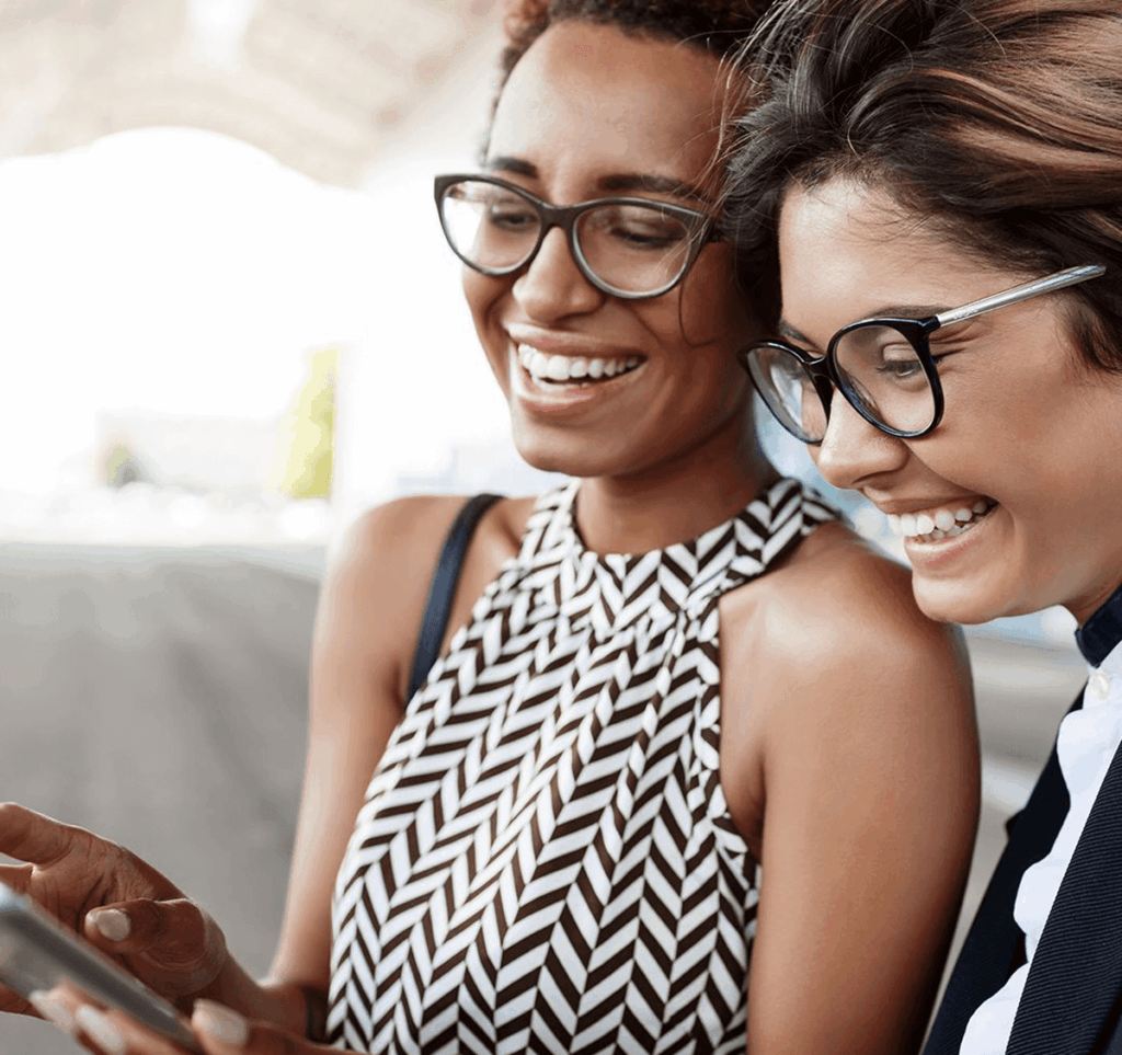 Duas mulheres olhando para um celular.