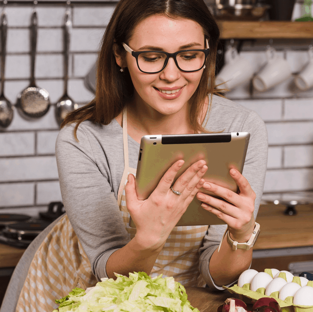 Mulher cozinhando com tablet na cozinha
